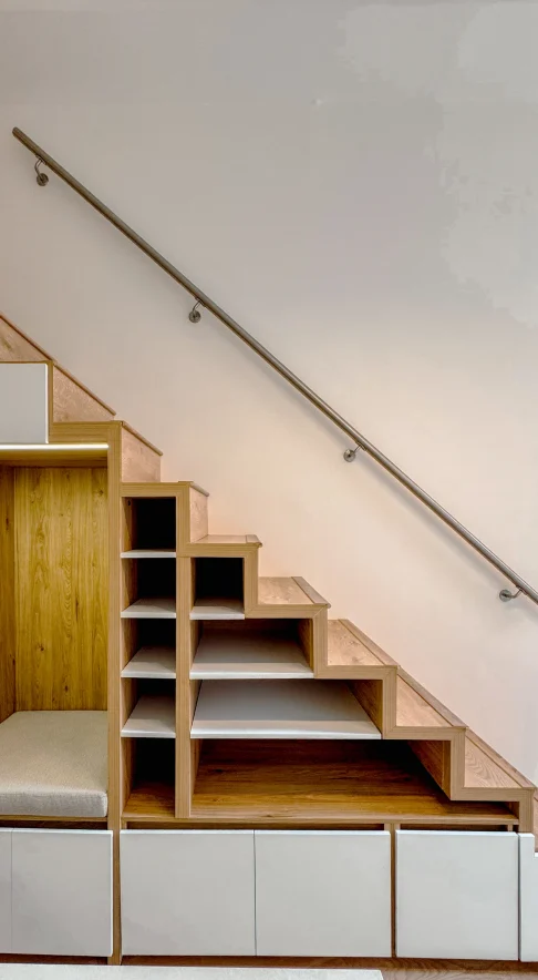 Escalera de madera con repisas, cajones y un asiento integrado bajo los peldaños.